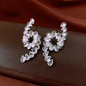 Detail shot of silver earrings with spiral teardrop design and sparkling zircon pavé