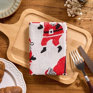 Christmas dinner napkin with Santa Claus print on linen texture and festive table setting