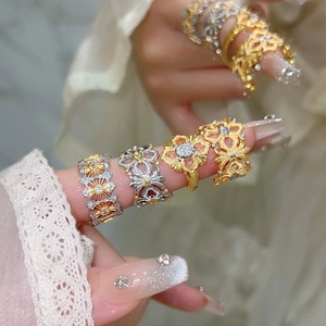 Ensemble de bagues vintage fleurs en or et argent avec zircons sur main