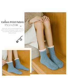 Close-up of blue coral fleece socks with white folded cuffs on a wooden stairs background