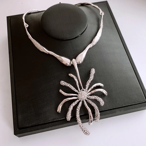 Détail du collier fleur argenté serti de cristaux avec une texture organique unique