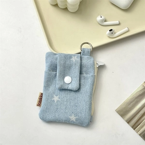 Detail view of denim card holder featuring star patterns and a secure metal D-ring hook