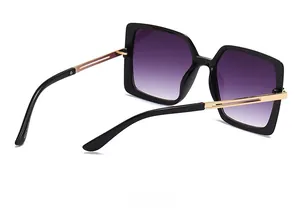 Detail view of vintage square sunglasses featuring purple gradient lenses and gold temples