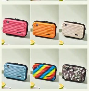 Mini hardshell suitcase bags in vibrant colors showing textured stripes and compact design