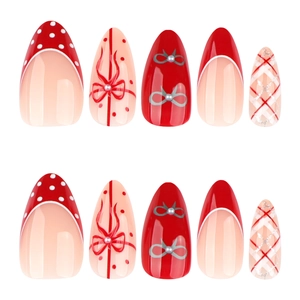 Red almond press-on nails with white polka dots, bow designs, and silver glitter patterns