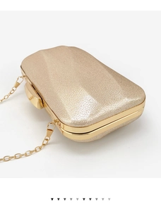 Detail of champagne gold evening clutch with glitter texture and chain strap