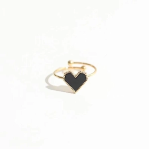 Bague dorée ajustable avec breloque cœur noir et bordure perlée sur fond blanc neutre