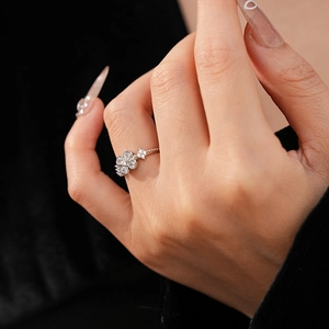 Close-up of a silver flower star ring with zircon stones worn on a finger