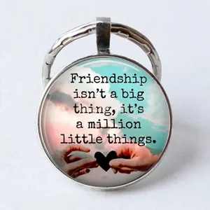 Detail of friendship glass cabochon keychain showing sunset heart and quote