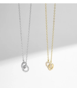 Detail of interlocking double ring necklace in gold and silver with sparkling gems