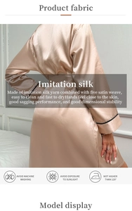 Détail du peignoir en satin champagne avec bordures noires et texture de tissage satiné