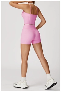 Détail de l'ensemble de yoga rose avec coutures blanches sur le débardeur et le short