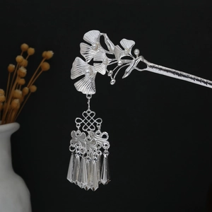 Detail of silver ginkgo leaf hair pin with delicate white pearls and hanging tassels