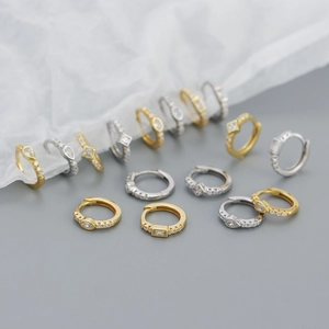 Close-up of gold and silver S925 sterling silver huggie earrings with sparkling cubic zirconia