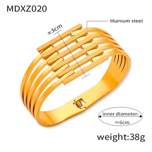 Detailed view of wide gold-plated titanium steel cuff with multi-layer hollow design