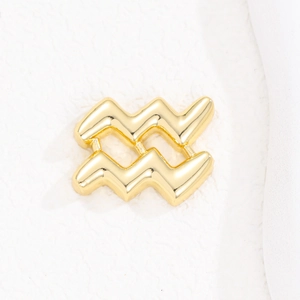 Macro detail of high-polish gold Aquarius zodiac bubble pendant with smooth mirror finish
