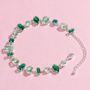 Detail view of silver bracelet with green cubic zirconia in various geometric cuts