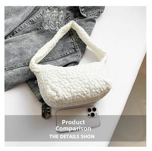 Close-up of white quilted flower texture on a puffy shoulder bag with wide strap