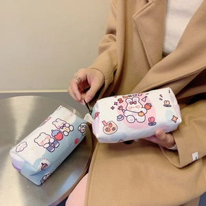 Close-up of cute cartoon canvas pencil cases in light blue and white held by hand