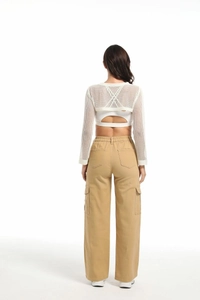 Detail view of khaki multi-pocket cargo pants with white mesh shrug from the back side