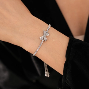 Close-up of elegant silver bow bracelet with sparkling zircons worn on model's wrist