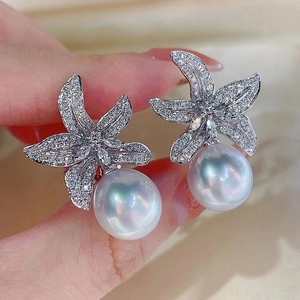 Close-up of elegant starfish flower earrings with white pearls and sparkling zircons