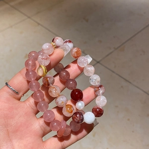 Close-up of pink strawberry quartz and pearl beaded bracelets with gold accents