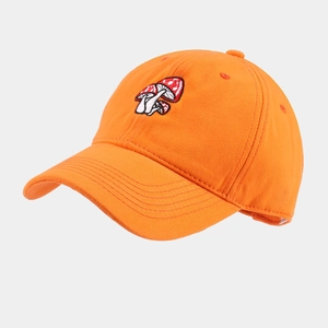 Close-up of three mushroom embroidery on an orange cotton twill baseball cap with curved brim