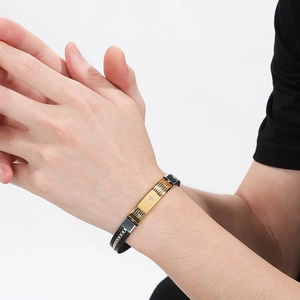Close-up of black silicone wristband with gold stainless steel bible verse engraving