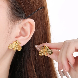 Minimalist gold honey bee stainless steel stud earrings shown on model for women