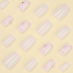Unghie finte corte quadrate bianco latte con motivi floreali rosa e piccoli strass lucidi
