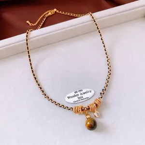 Detailed close-up of tiger eye stone pendant with golden beads and spiral metal rings