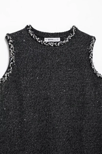 Detail of the dark grey knit sleeveless top with silver sequins and brand label on white