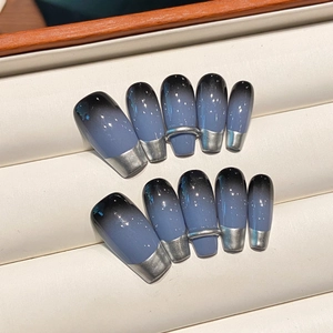 Detailed view of blue-black gradient press-on nails with silver French tips and 3D rings