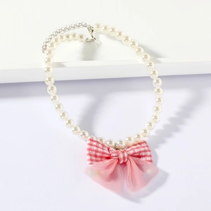 Detailed view of white pearl pet necklace with pink plaid bow and adjustable metal clasp