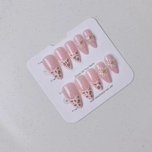 Détails d'ongles amande roses style français avec motif léopard et fleurs 3D sur présentoir