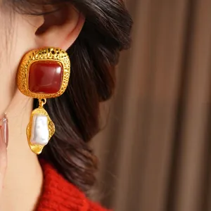 Vintage gold textured square resin earrings with baroque pearls worn by a model