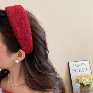 Close-up of a thick red plush headband worn by a model for a stylish high-top look