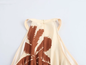Detail of beige halter dress showing tropical palm leaf print and hidden back zipper