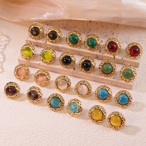 Detailed close-up of retro cat-eye stud earrings with gold plating and quilted texture
