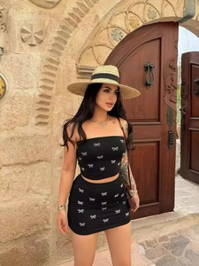 Sexy black two-piece set with bow print crop tube top and mini skirt outfit for women