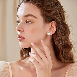 Close-up of golden reindeer earrings with clear crystal stones on a female model