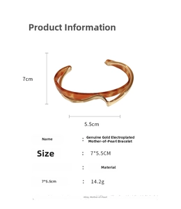 Detail showing double-layered wavy gold cuff with shell inlay and product specifications