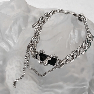 Detail of titanium steel bracelet featuring black stone pendant and double chain OT clasp