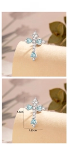 Detail of silver cross earring with heart-shaped blue stones and size measurements