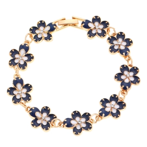 Close-up of vintage gold floral bracelet with blue and white enamel petals and zircons