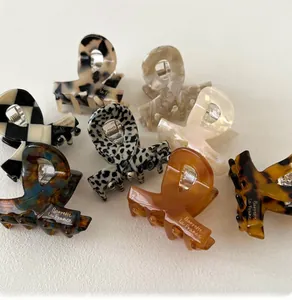 Detailed view of various acetate hair claws with shell, checkerboard, and marble patterns