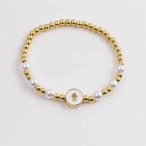 Fashion Hamsa hand charm bracelet with gold beads and white pearls on a clean background