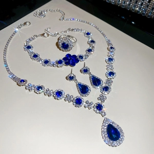 Detailed view of silver jewelry set with blue teardrop crystals and floral rhinestones