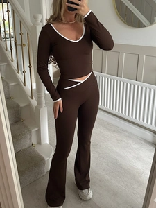 Détail de l'ensemble yoga marron à col V et pantalon évasé avec liserés blancs contrastés